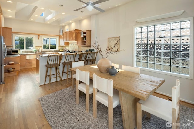 dining area with light wood-style flooring, ceiling fan, recessed lighting, and a skylight