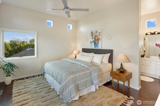 bedroom with multiple windows, wood finished floors, baseboards, and ensuite bathroom