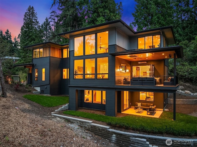 rear view of house featuring a yard, a patio area, a balcony, and an outdoor hangout area