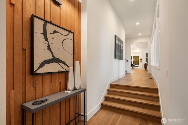 stairway featuring baseboards, wood finished floors, and recessed lighting
