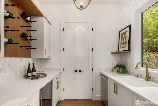 interior space with wine cooler, a dry bar, a sink, light wood-style floors, and dishwasher