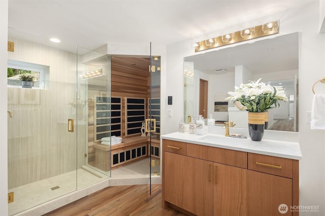bathroom with wood finished floors, vanity, and a stall shower