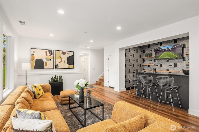 living room featuring recessed lighting, wood finished floors, visible vents, and stairway
