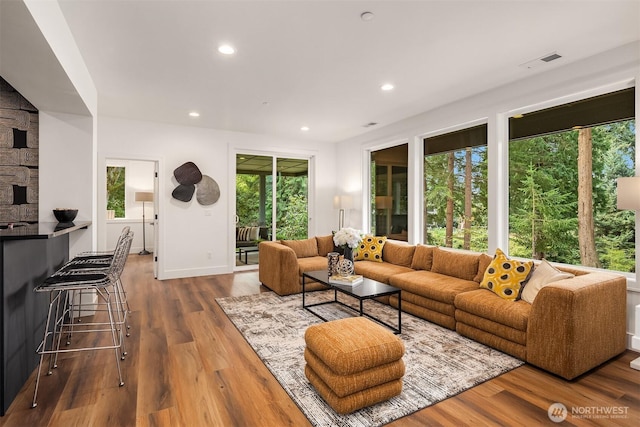 living room featuring baseboards, wood finished floors, visible vents, and recessed lighting