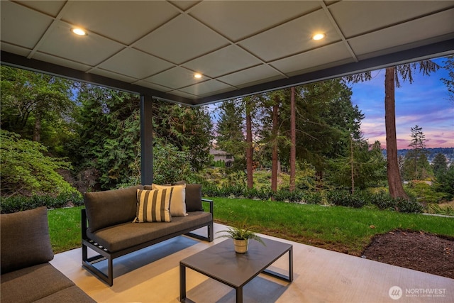 patio terrace at dusk featuring outdoor lounge area and a yard
