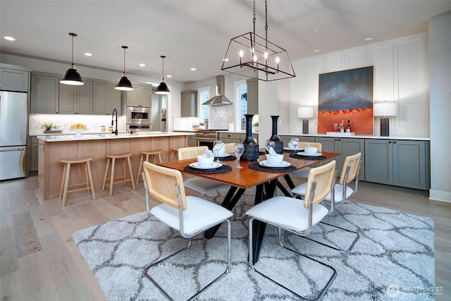 dining room featuring an inviting chandelier, light wood-style flooring, and recessed lighting