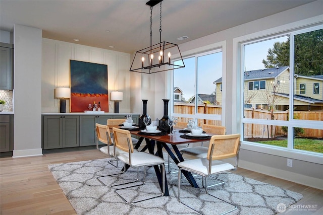dining space with light wood-type flooring, visible vents, and plenty of natural light