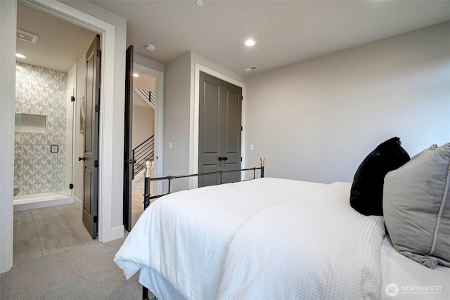 bedroom featuring recessed lighting, visible vents, light carpet, and ensuite bath