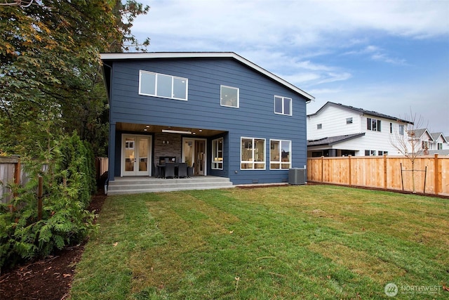 back of house with a lawn, a patio, and a fenced backyard