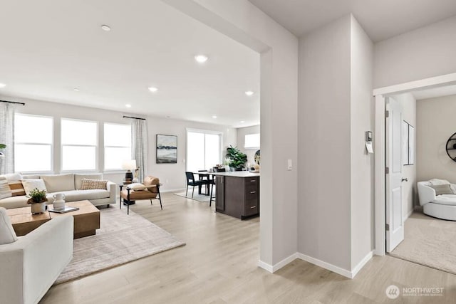 living room with baseboards, recessed lighting, and light wood-type flooring