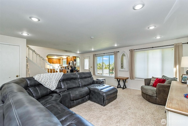 living area with stairway, recessed lighting, baseboards, and arched walkways