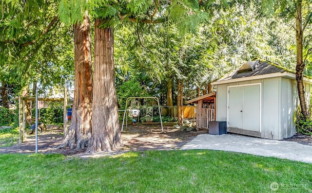 view of yard featuring a storage unit, fence, and an outdoor structure