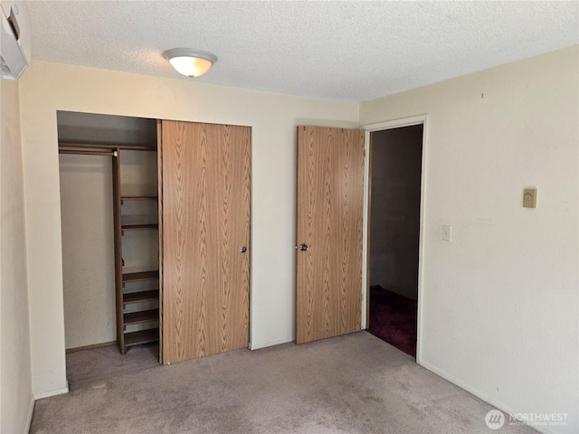 unfurnished bedroom with carpet, a closet, and a textured ceiling