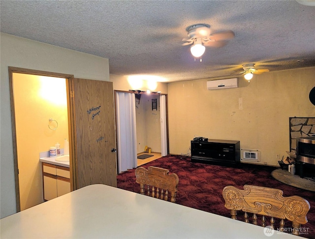 carpeted bedroom with a wall unit AC, a textured ceiling, and connected bathroom