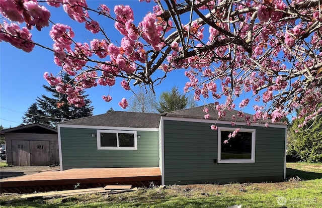 6321 Central Park Dr, Aberdeen, WA 98520 - view of home's exterior with a wooden deck, a lawn, an outdoor structure, and roof with shingles