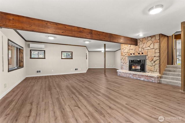 6044 Buckthorn Ct NW, Olympia, WA 98502 - unfurnished living room with baseboards, wood finished floors, an AC wall unit, and beam ceiling