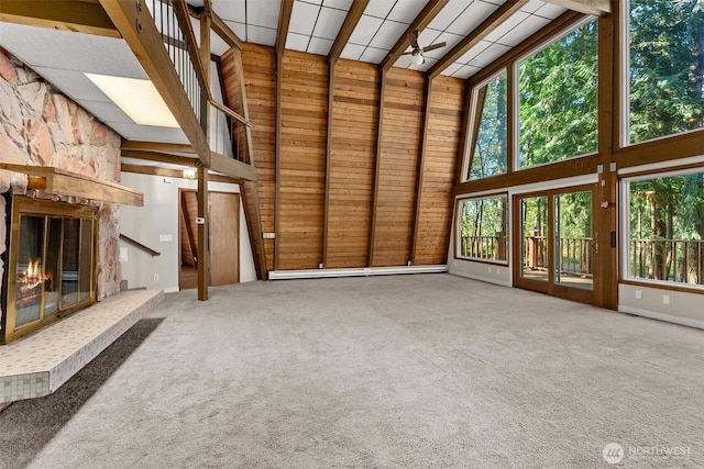 6044 Buckthorn Ct NW, Olympia, WA 98502 - unfurnished living room featuring a ceiling fan, a stone fireplace, a high ceiling, wood walls, and carpet flooring