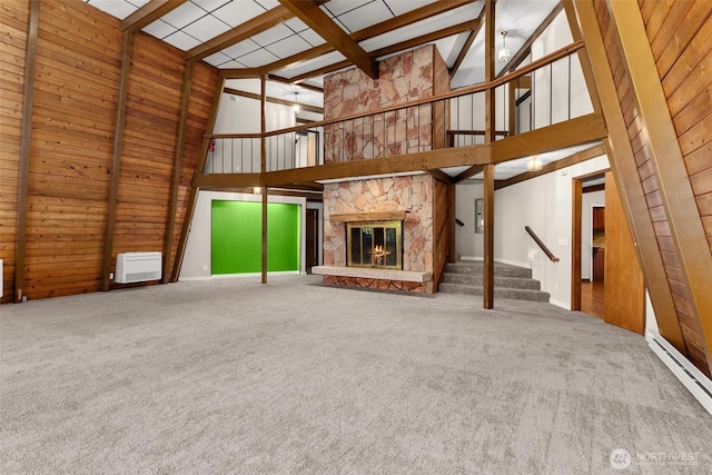 6044 Buckthorn Ct NW, Olympia, WA 98502 - unfurnished living room with high vaulted ceiling, a baseboard radiator, stairway, a stone fireplace, and carpet