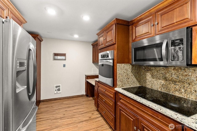 6044 Buckthorn Ct NW, Olympia, WA 98502 - kitchen featuring stainless steel appliances, light wood finished floors, backsplash, baseboards, and light stone countertops
