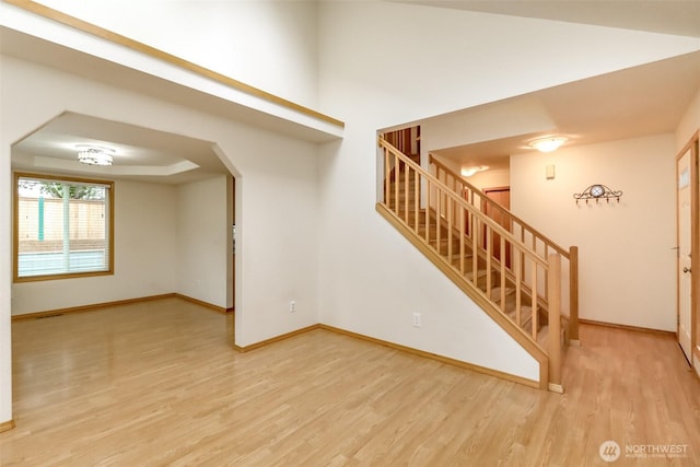 5475 Park Place Loop SE, Lacey, WA 98503 - spare room with wood finished floors, baseboards, stairway, and arched walkways