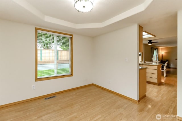 5475 Park Place Loop SE, Lacey, WA 98503 - empty room with a raised ceiling, light wood-style flooring, baseboards, and ceiling fan