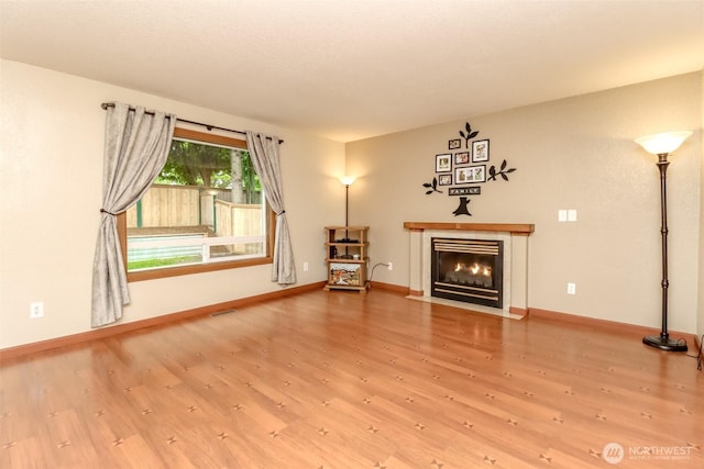 5475 Park Place Loop SE, Lacey, WA 98503 - unfurnished living room with wood finished floors, baseboards, and a fireplace with flush hearth