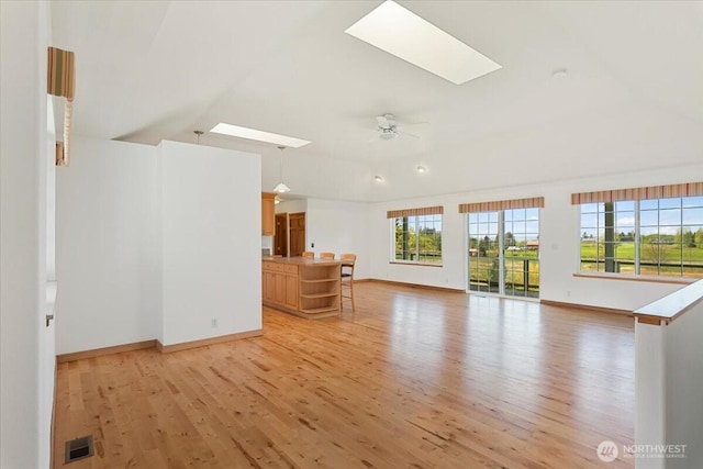 30729 76th Ave NW, Stanwood, WA 98292 - living area featuring lofted ceiling with skylight, light wood-style flooring, visible vents, and baseboards