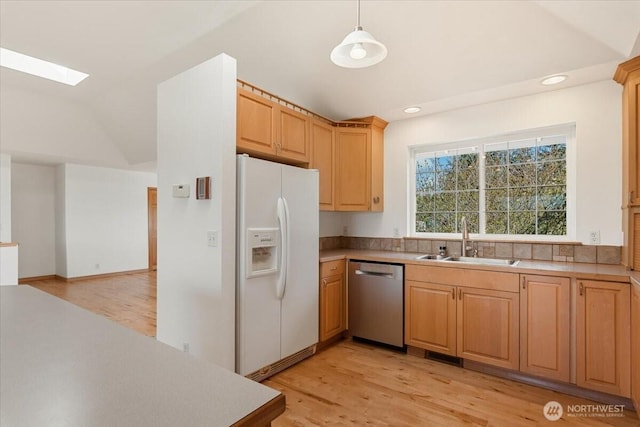 30729 76th Ave NW, Stanwood, WA 98292 - kitchen with lofted ceiling with skylight, a sink, light wood-style floors, white fridge with ice dispenser, and dishwasher