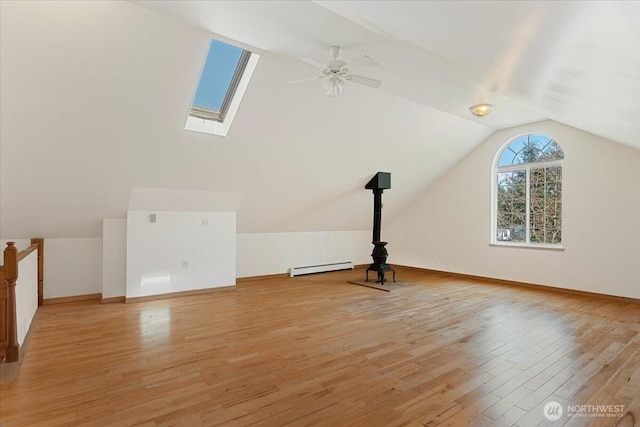 30729 76th Ave NW, Stanwood, WA 98292 - bonus room featuring a baseboard heating unit, baseboards, light wood-style floors, vaulted ceiling with skylight, and a ceiling fan