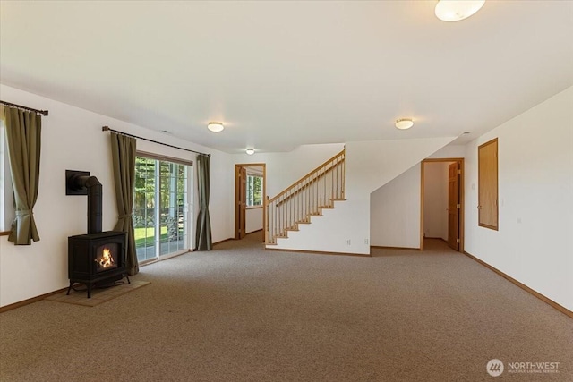 30729 76th Ave NW, Stanwood, WA 98292 - unfurnished living room featuring stairway, a wood stove, baseboards, and light carpet