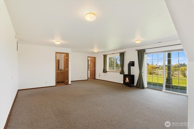 30729 76th Ave NW, Stanwood, WA 98292 - carpeted spare room featuring a wood stove and baseboards