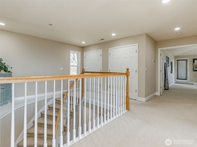 hallway with light colored carpet, baseboards, an upstairs landing, and recessed lighting