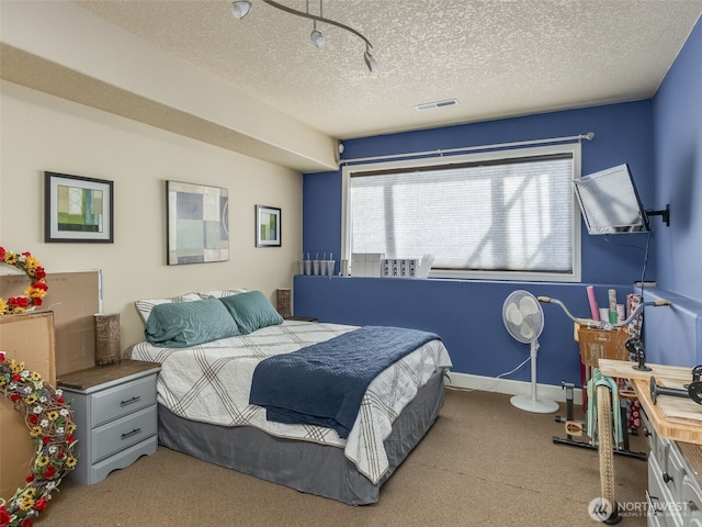 bedroom with a textured ceiling, carpet, and visible vents