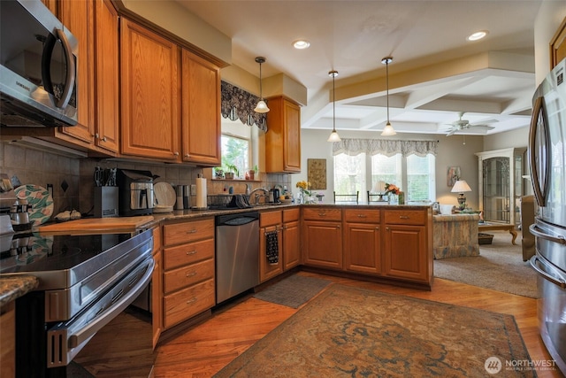 4404 Landmark Dr, Mount Vernon, WA 98274 - kitchen with stainless steel appliances, backsplash, coffered ceiling, pendant lighting, and brown cabinets