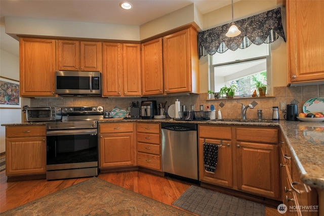 4404 Landmark Dr, Mount Vernon, WA 98274 - kitchen with brown cabinets, wood finished floors, appliances with stainless steel finishes, and a sink
