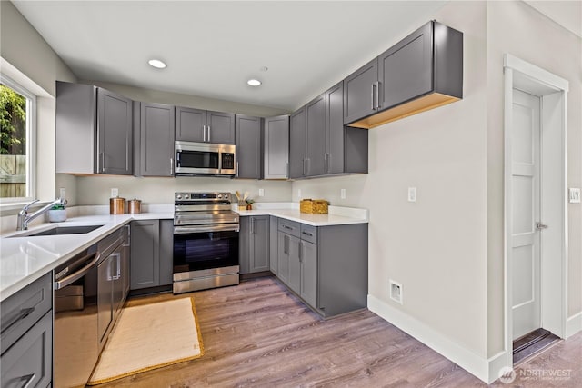 13055 2nd Ave S Unit B, Burien, WA 98168 - kitchen featuring stainless steel appliances, gray cabinetry, light wood-style flooring, recessed lighting, and light countertops