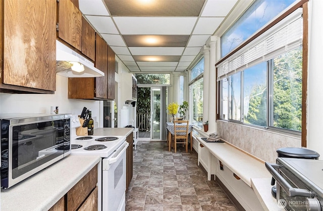 3512 Grand Ave, Everett, WA 98201 - kitchen with white electric range oven, a toaster, light countertops, under cabinet range hood, and stone finish floor