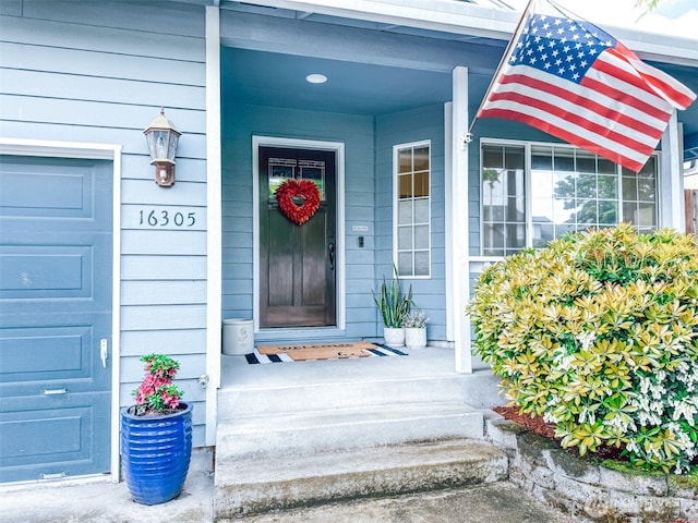 view of exterior entry featuring covered porch