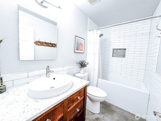 bathroom featuring vanity, shower / tub combo with curtain, visible vents, toilet, and tile walls