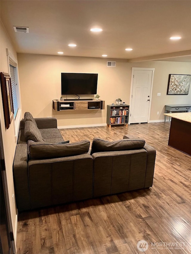 living room with visible vents, wood finished floors, and recessed lighting