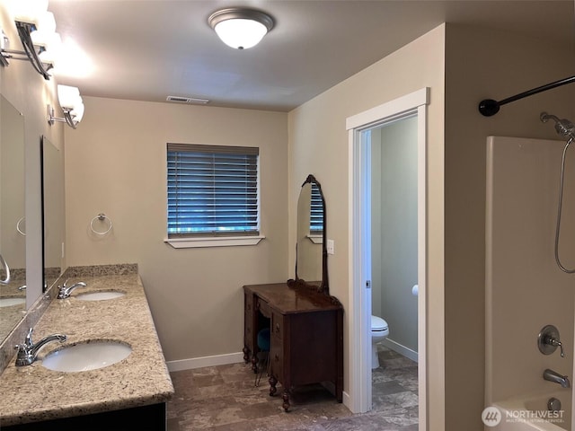 bathroom featuring a sink, toilet, baseboards, and visible vents