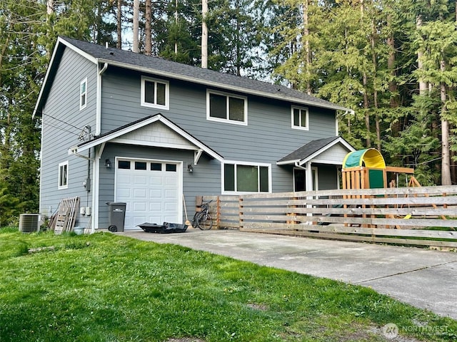 view of front of property featuring driveway, fence, an attached garage, central AC unit, and a front yard
