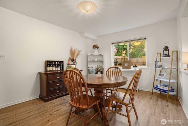 dining area with baseboards and light wood-style flooring