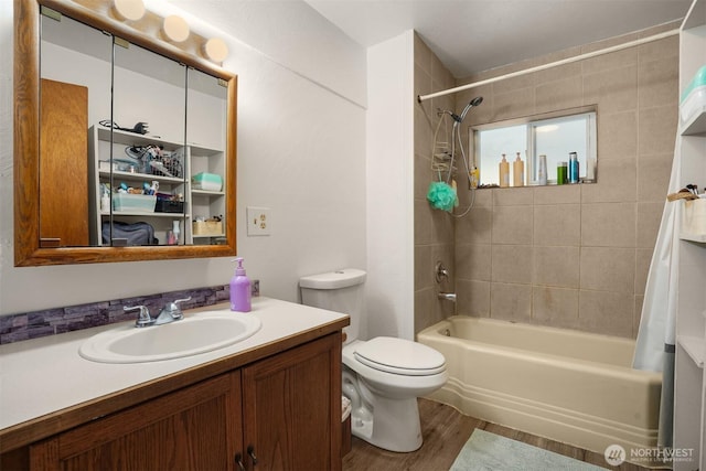 bathroom with toilet, wood finished floors, vanity, and shower / tub combo with curtain