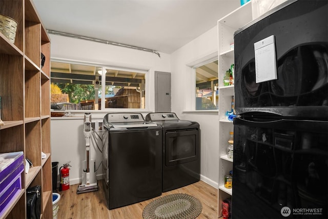 laundry area with separate washer and dryer, baseboards, wood finished floors, and laundry area