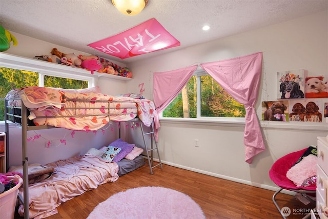 bedroom with baseboards, wood finished floors, a textured ceiling, and recessed lighting