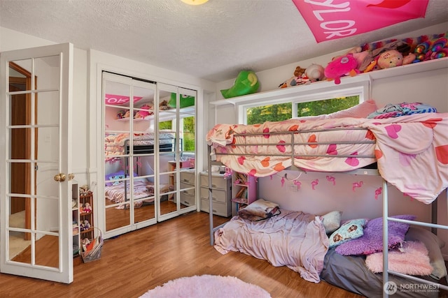bedroom featuring wood finished floors and a textured ceiling