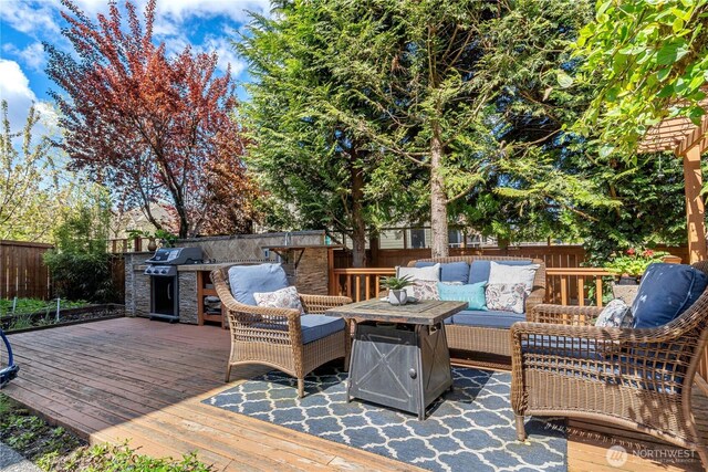 10788 243rd Ave NE, Redmond, WA 98053 - wooden deck with outdoor lounge area, a grill, a fenced backyard, and exterior kitchen