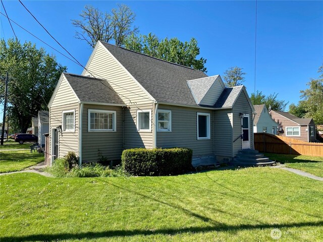 70 NE Rose St, College Place, WA 99324 - view of property exterior with a lawn, roof with shingles, and fence