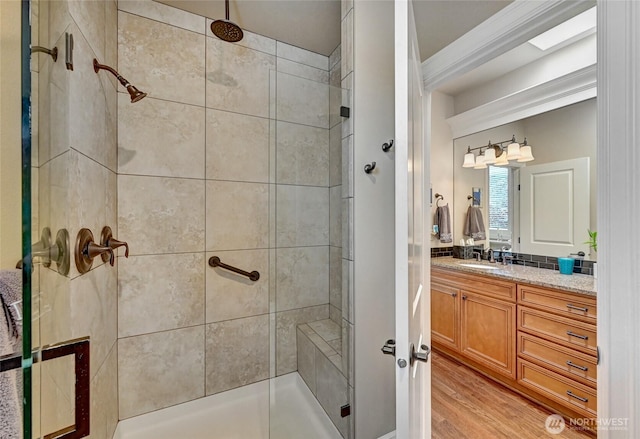 full bathroom with vanity, a stall shower, and wood finished floors